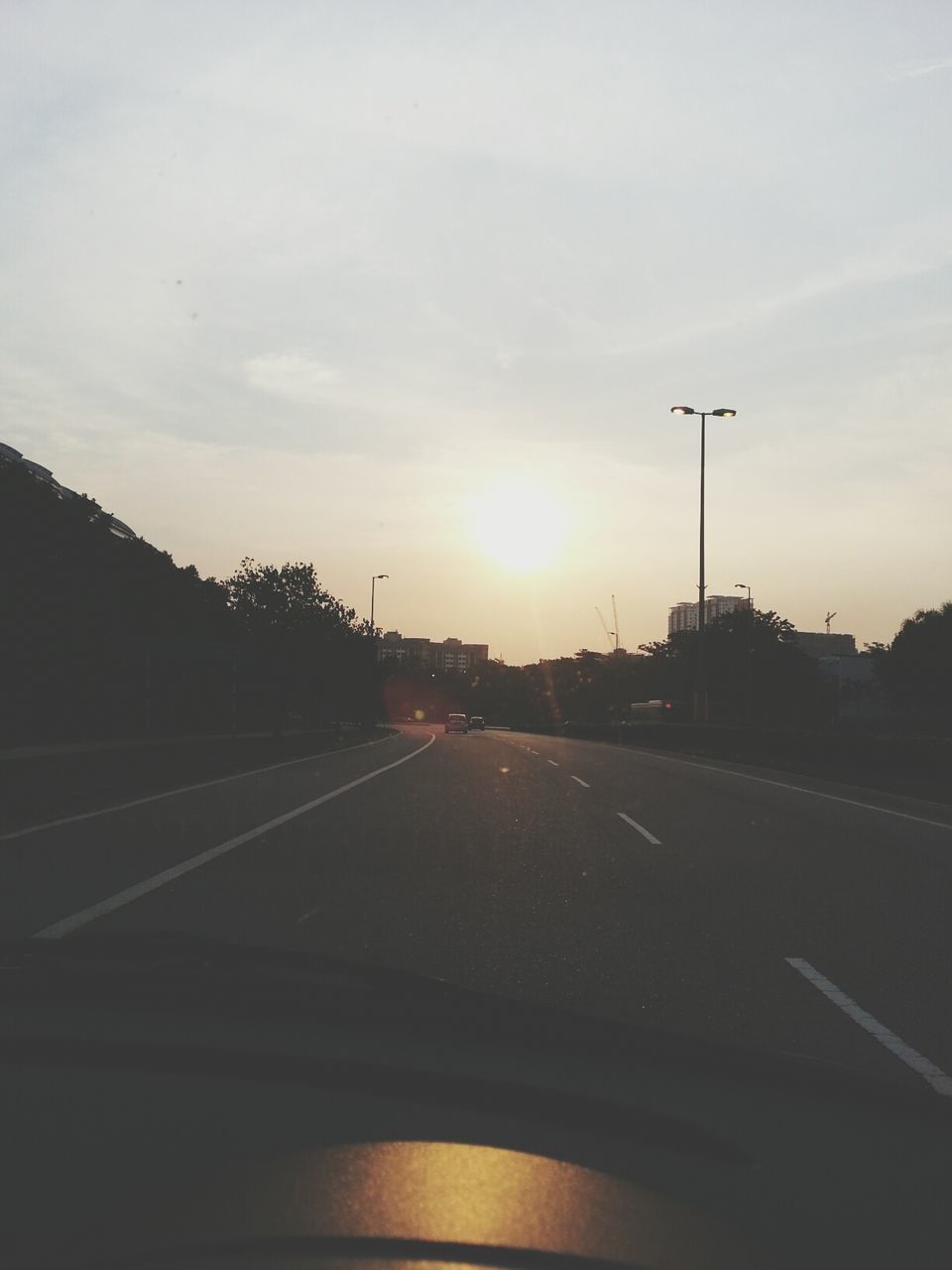 transportation, sunset, road, sky, the way forward, car, road marking, silhouette, land vehicle, mode of transport, street light, street, cloud - sky, diminishing perspective, sun, sunlight, vanishing point, cloud, outdoors, no people