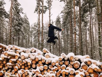 Man jumping on snow covered landscape