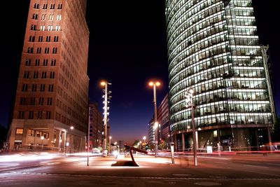 Light trails on road along buildings at night