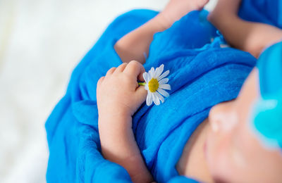 Baby with flower sleeping on bed at home