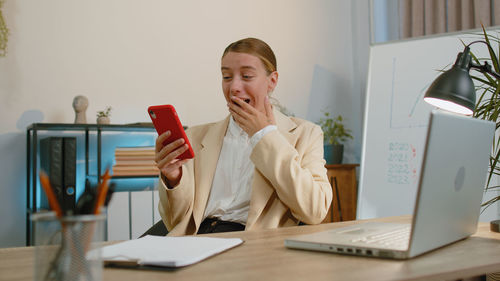 Portrait of young woman using laptop at office