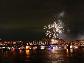 Firework display over river at night