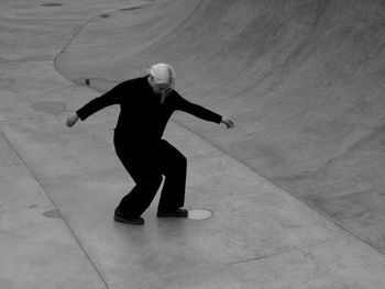 Woman in black dancing on the grey concrete 