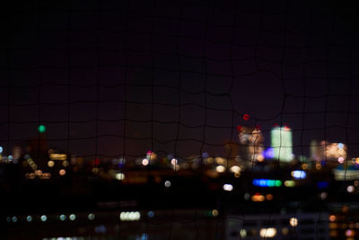 Illuminated cityscape against sky at night