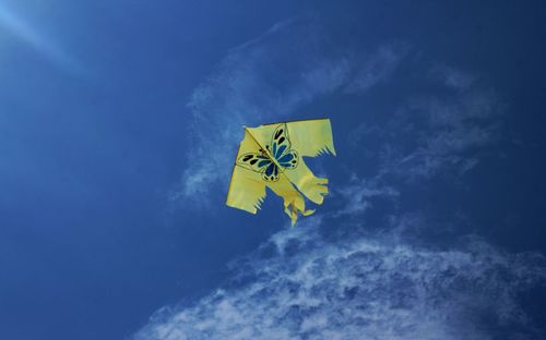 Low angle view of flag against blue sky