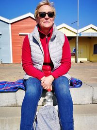 Senior woman sitting on retaining wall