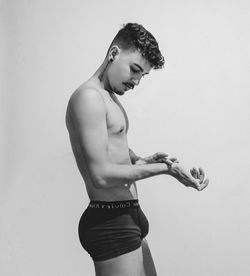 Young man looking away against white background