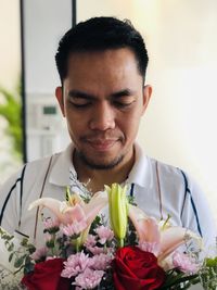 Portrait of young man with red roses