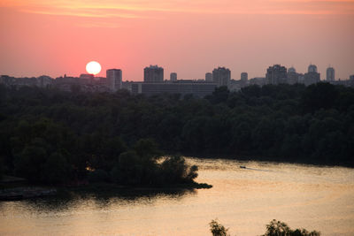 View of city at waterfront during sunset