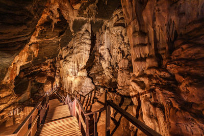 The wooden walking path through stalactite and stalagmite in phu pha petch cave at thailand