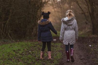 Rear view of 2 girls holding hands