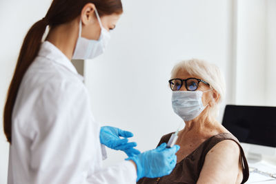 Doctor vaccinating senior patient at clinic