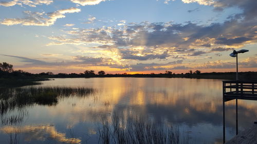 Scenic view of lake against sky at sunset