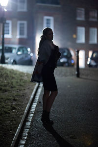 Full length of woman standing on street in city