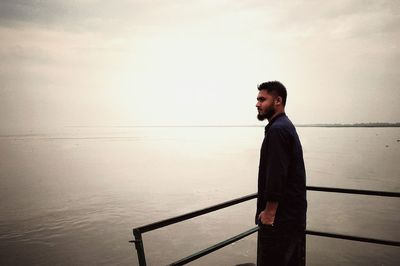 Side view of young man looking at sea