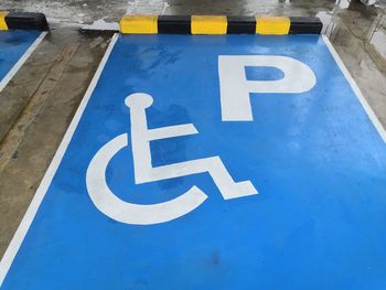 High angle view of parking and wheelchair access sign on road