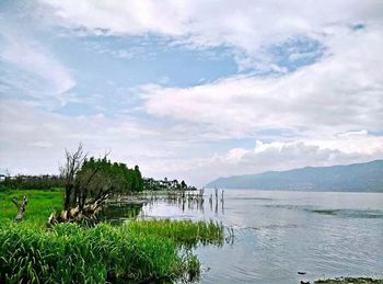 Scenic view of lake against cloudy sky