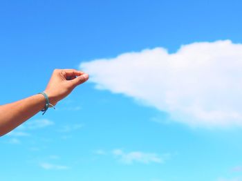 Low angle view of cropped hand against clear sky