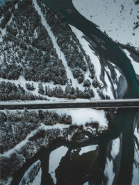 Drone shot of snow covered river bank with bridge 