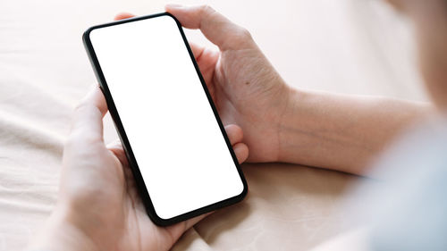 Close-up of hand holding mobile phone