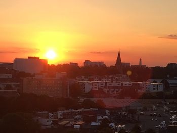 Buildings in town against sky during sunset