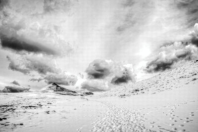 Scenic view of snow covered land against sky