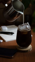 A scene of pouring milk into coffee