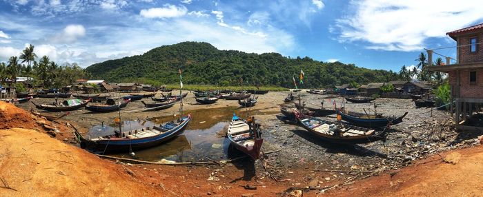 Panoramic view of boats moored at shore against sky