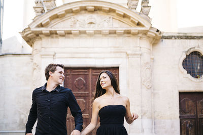 Couple walking against historic building