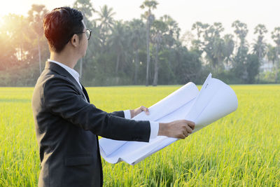 Side view of young man standing on field