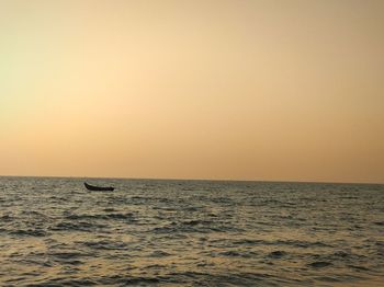 Scenic view of boat in sea against clear sky during sunset