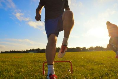 Low section of male soccer player training on grassy field