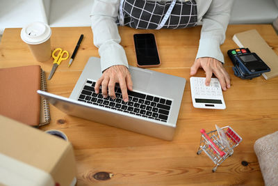 Midsection of man using laptop on table