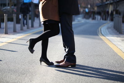 Low section of man walking on road