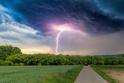 Scenic view of lightning over field against sky