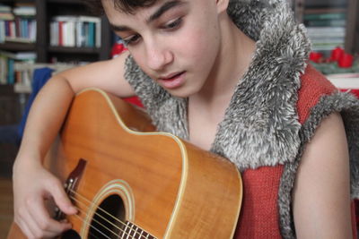 Boy playing guitar at home