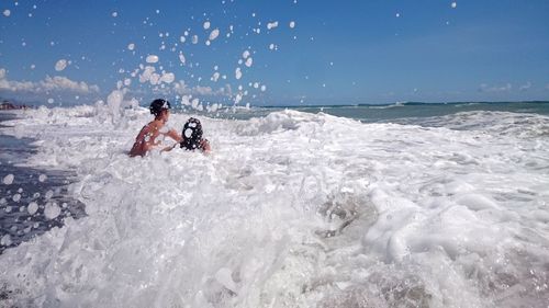 Man surfing on sea against sky