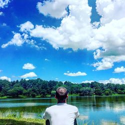 Rear view of man in water against sky