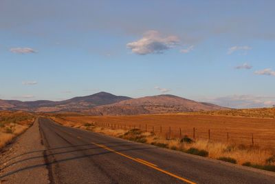 Road by mountains against blue sky