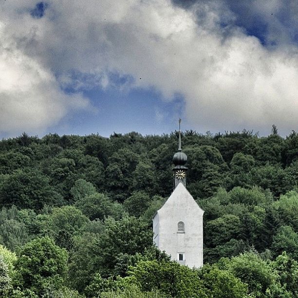 tree, architecture, building exterior, built structure, sky, religion, cloud - sky, green color, growth, spirituality, church, place of worship, nature, low angle view, cloudy, lush foliage, beauty in nature, cloud, scenics