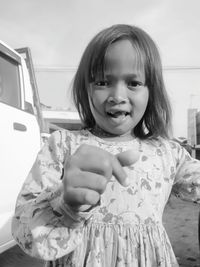 Portrait of a smiling girl sitting on car