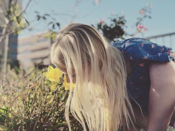 Midsection of woman with arms raised on field