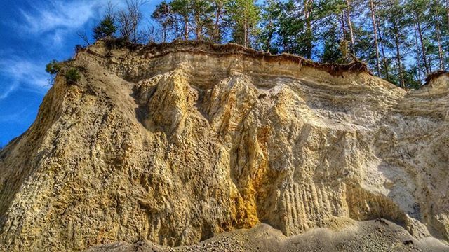 tranquility, rock formation, tranquil scene, sky, nature, scenics, beauty in nature, rock - object, low angle view, tree, geology, landscape, blue, physical geography, non-urban scene, eroded, sunlight, cliff, day, idyllic