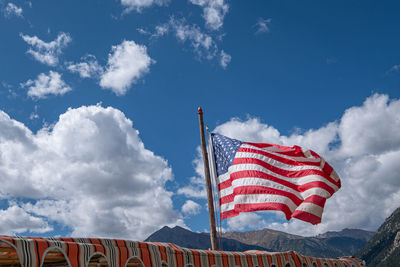 American flag in wind against clouds and blue sky