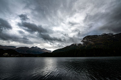 Scenic view of lake by mountains against sky