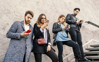 Young couple holding mobile phone outdoors