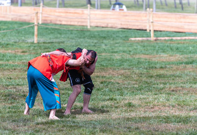 Rear view of men playing on field