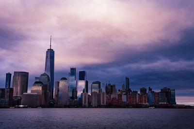 Modern buildings in city against cloudy sky