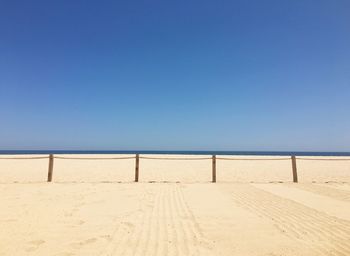 Scenic view of beach against clear blue sky