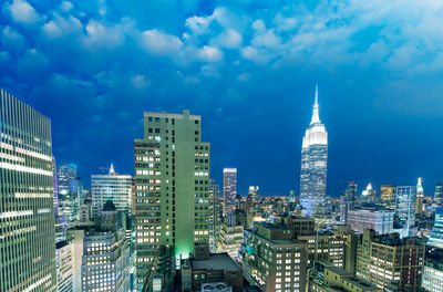 Modern buildings in city against cloudy sky